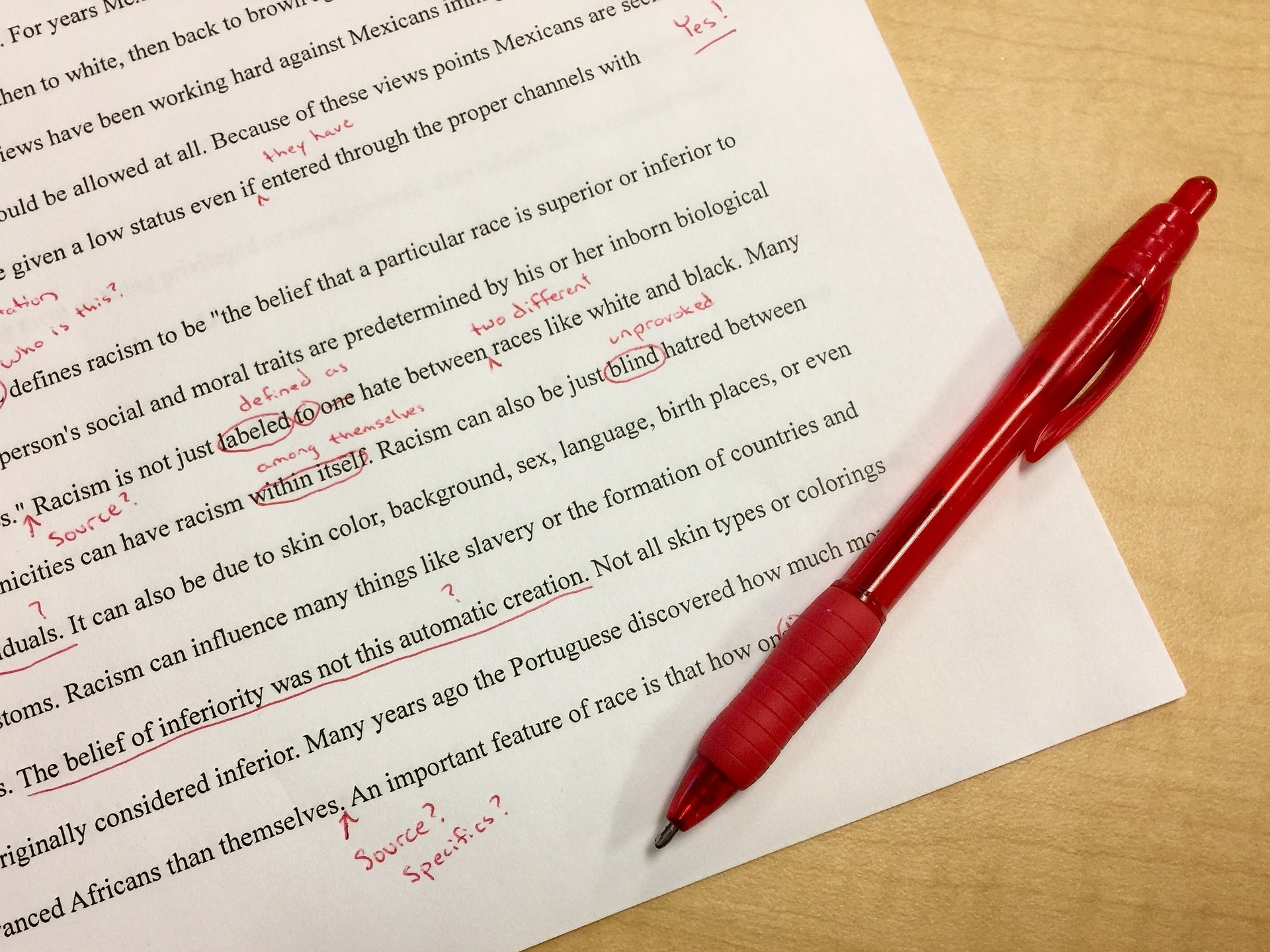 A sheet of paper with text marked with comments in red ink.