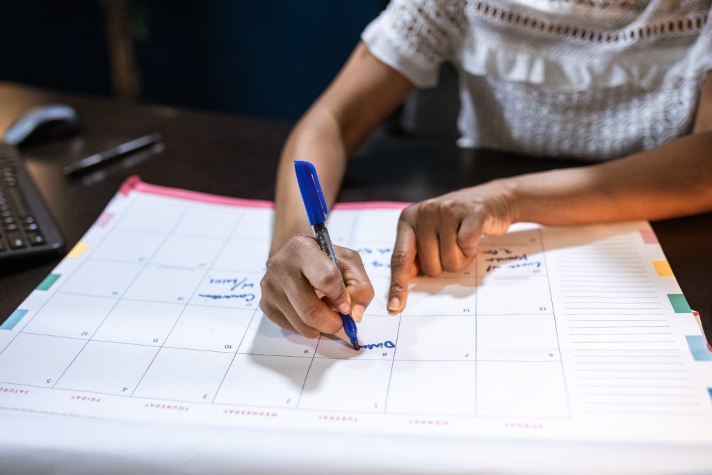 A person writing on a calendar. 