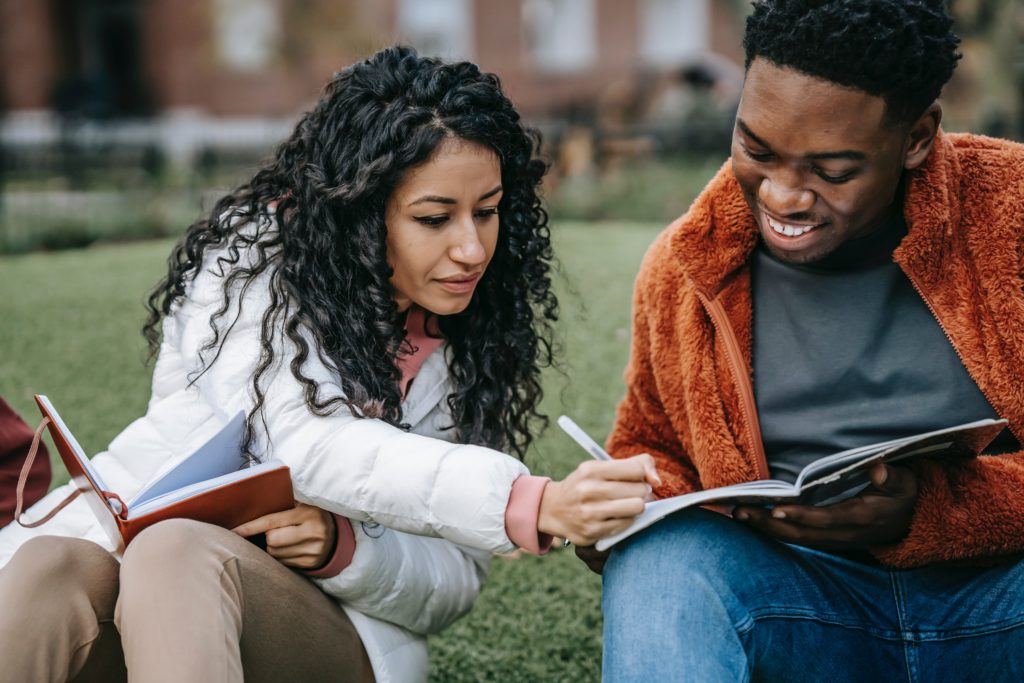 A woman and a man helping each other through writing. 