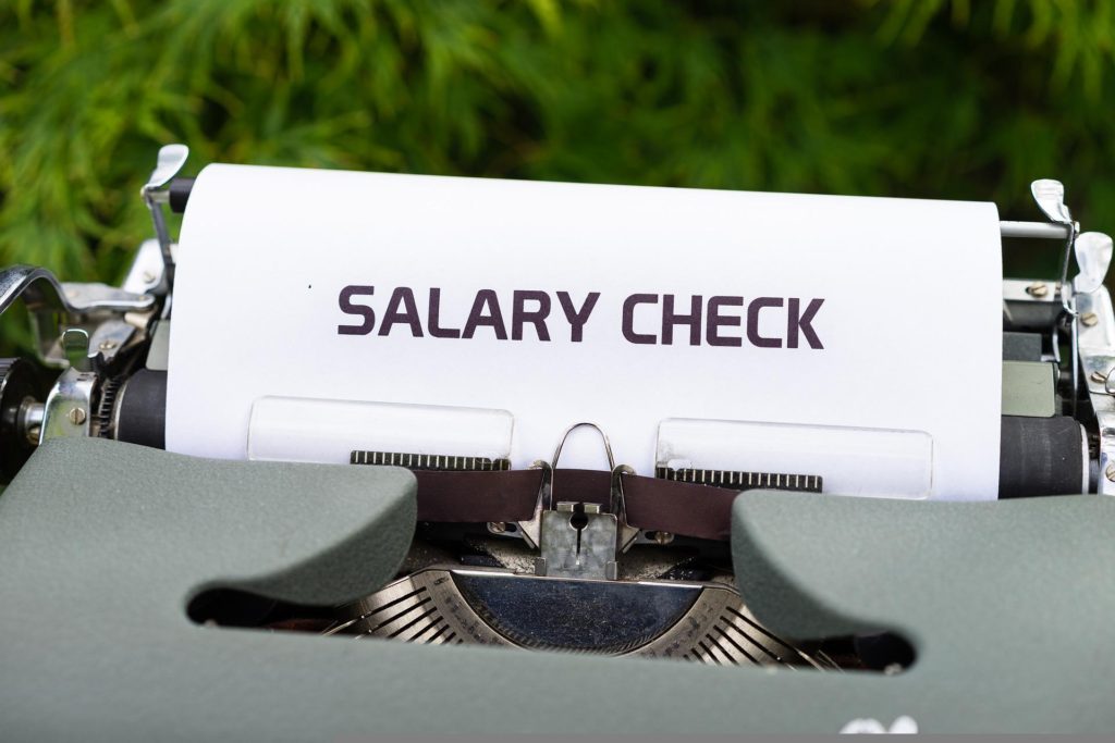 A typewriter with a sheet of paper on top that reads "Salary Check."