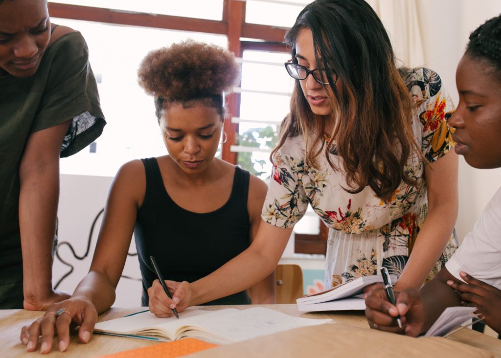 A group of people helping each other find inspiration during a writing session. 