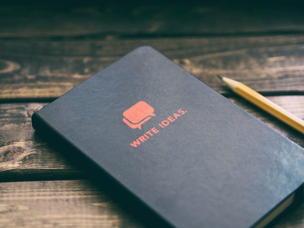 A writing journal and pencil on a table. 