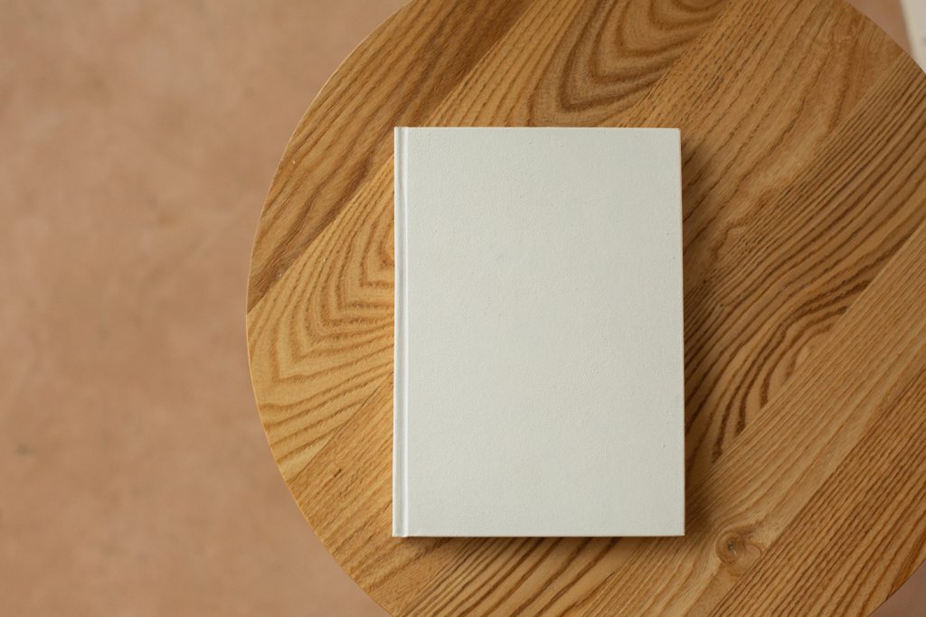 A white book with a blank cover on top of a table. 