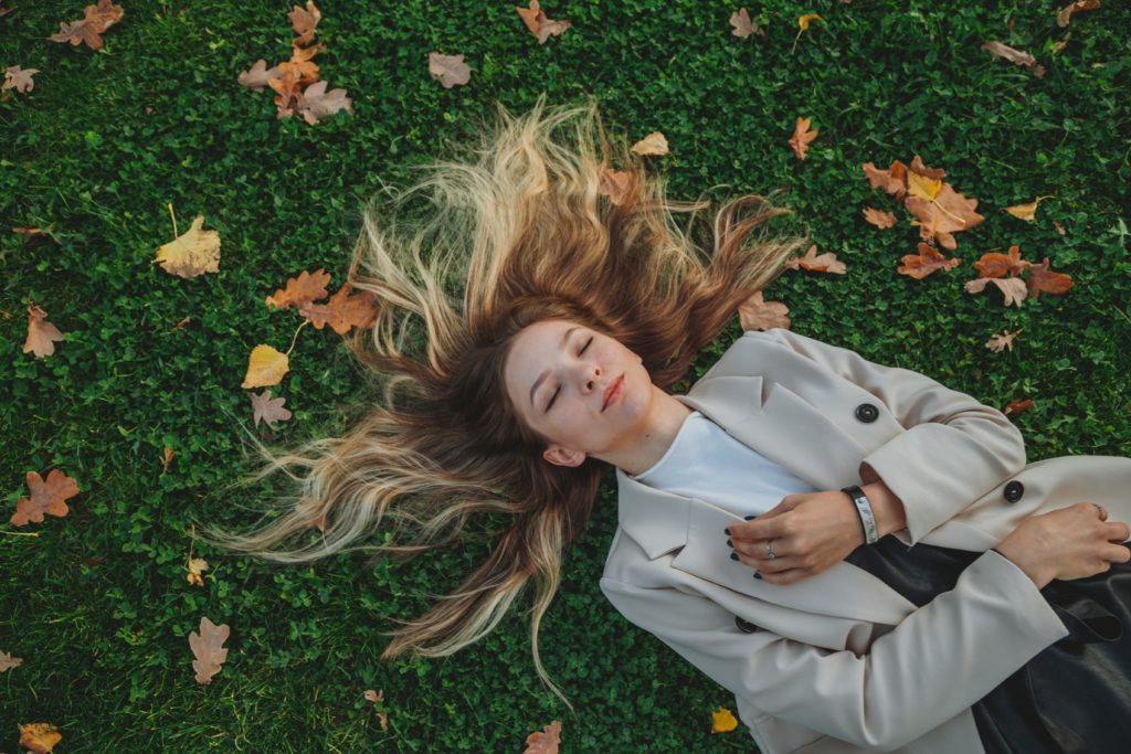 A woman taking a break by lying on the grass. 