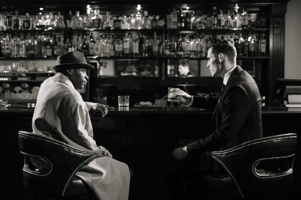 Two men having a conversation at a bar. 
