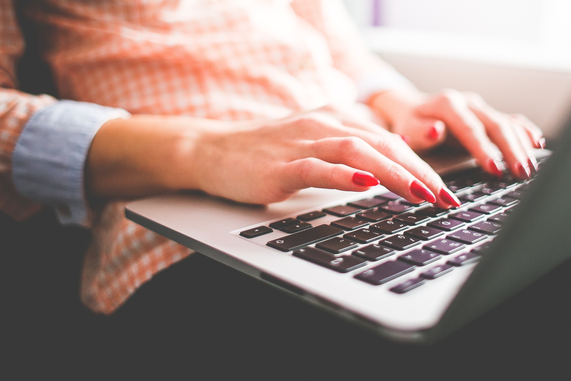 A woman typing on a laptop.