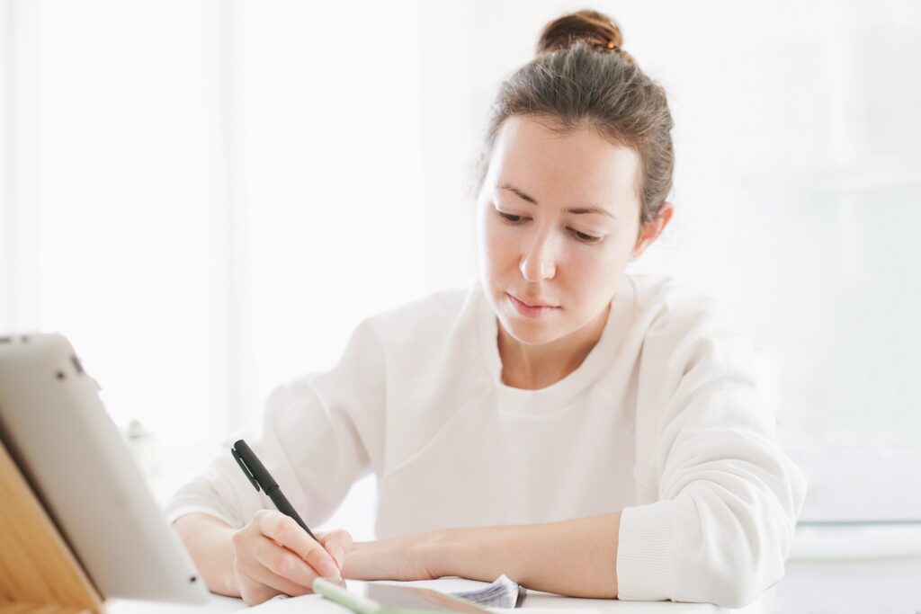 A woman writing a hook for her story. 