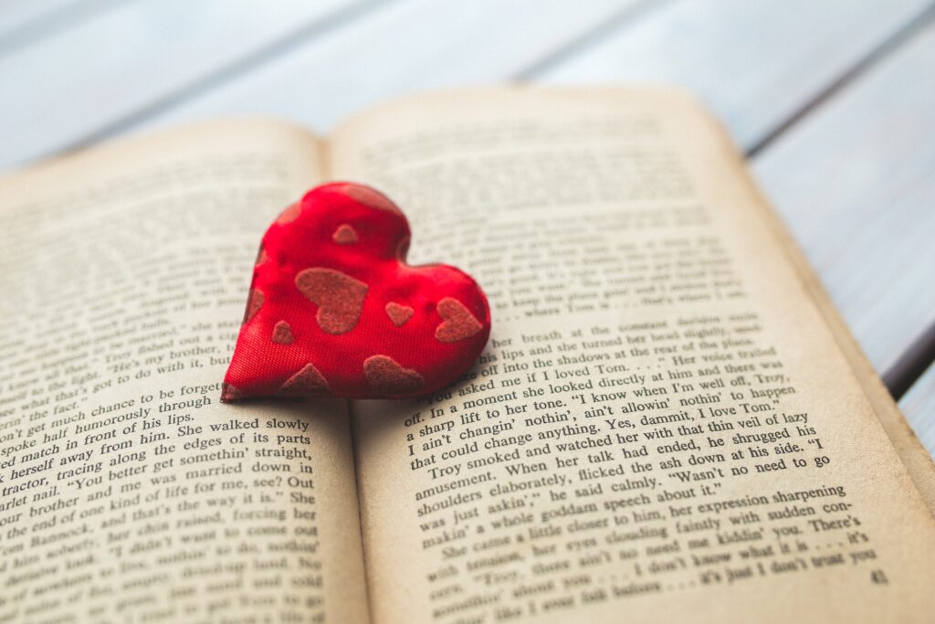 A red heart on a opened YA novel to read
