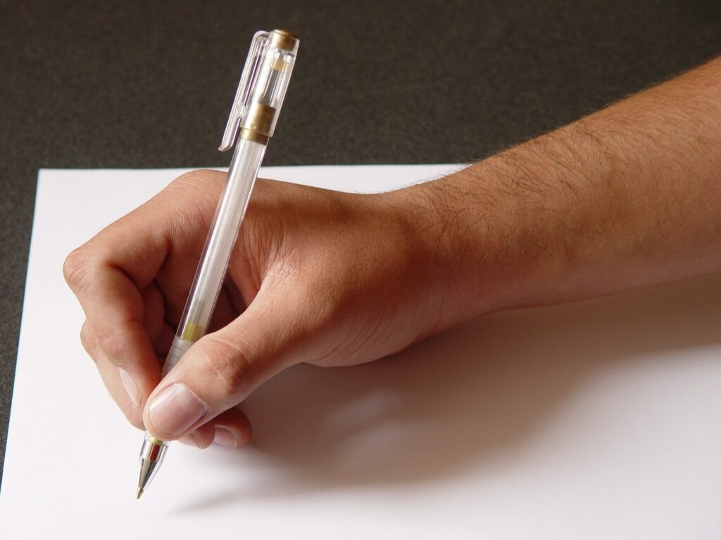 A person preparing to write on a blank page. 