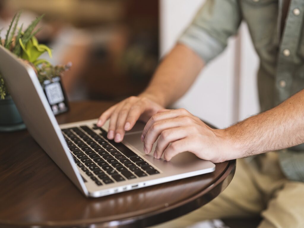 A person finding writing resources online with his computer. Resources online can help you get some good ideas for novel writing.