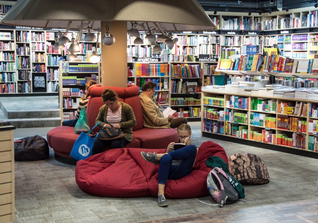Three people reading books at a bookstore. 