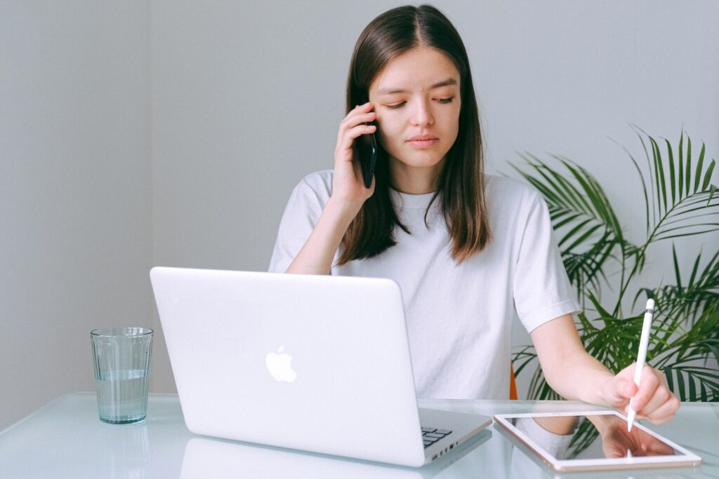 A woman providing guidance while using a silver a macbook.