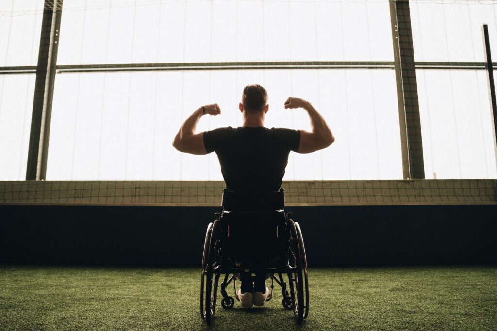 A man in a wheelchair flexing his muscles.
