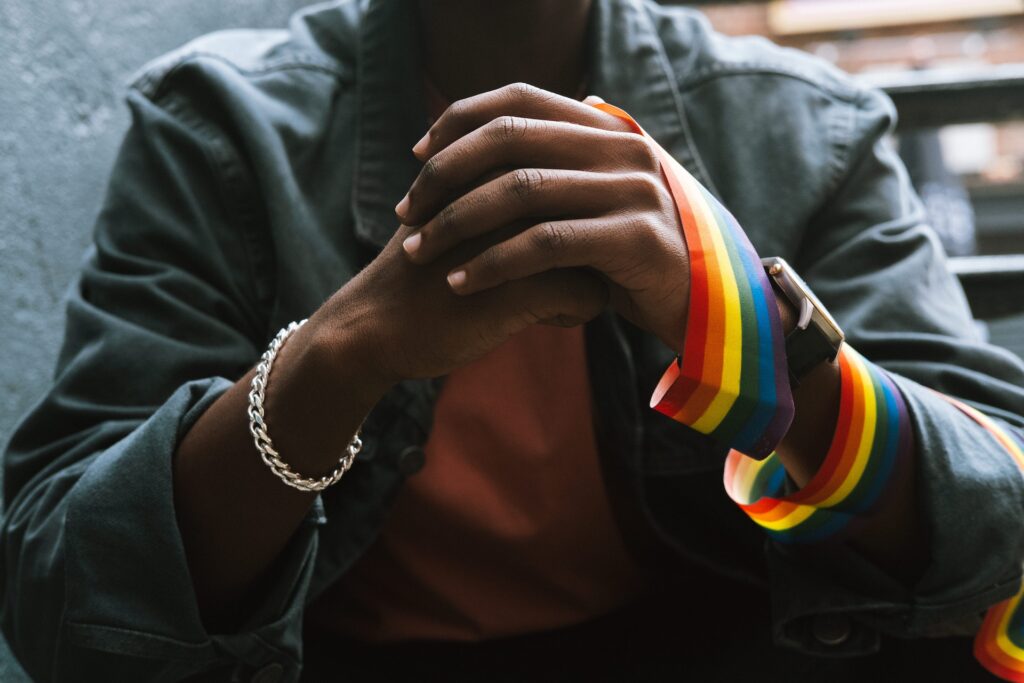 A black man with gay flag on hand. Self-discovery is an important change you can write for your YA hero's growth.