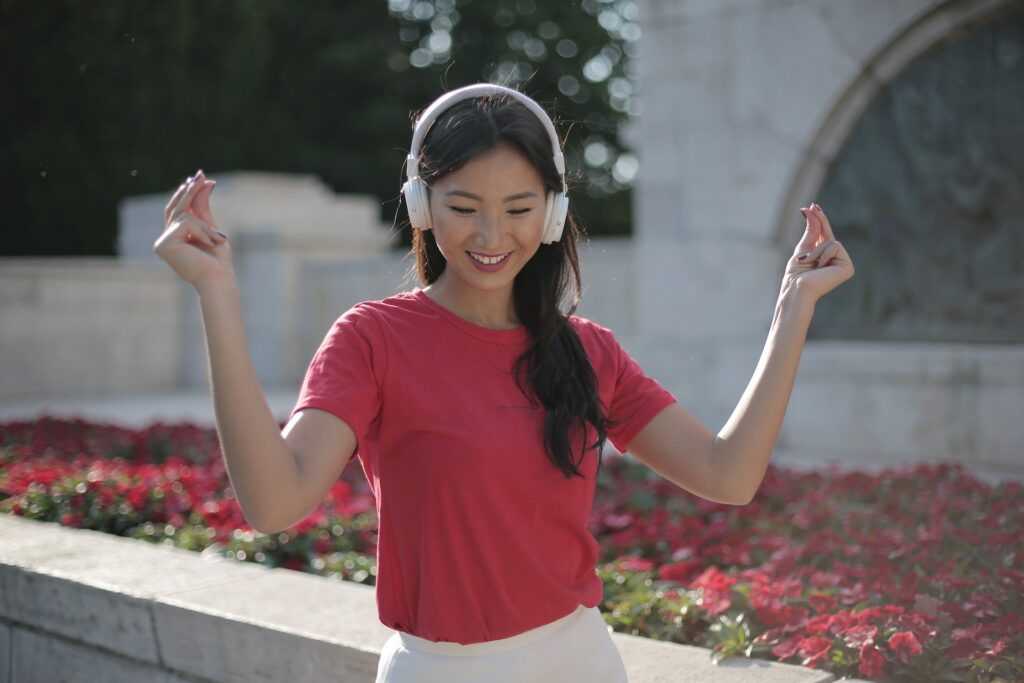 A woman dancing while listening to music. Self-expression is an important change you can write for your YA hero's growth.