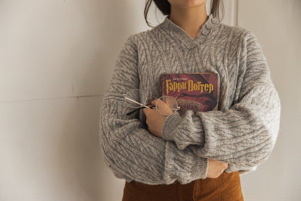 A woman holding a book. Relatability is a YA character development that can authentically connect with readers.